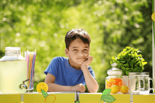 boy waiting for customers at his lemonade stand