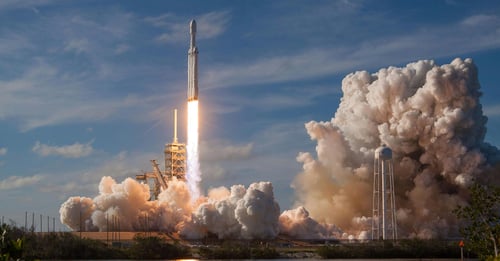 Gray spacecraft taking off during daytime