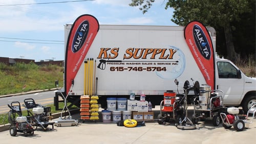 company truck with various products in front of it