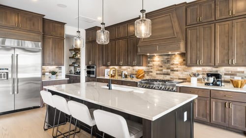 Chef-inspired kitchen with expansive island, pendant lighting and premium stainless steel appliances