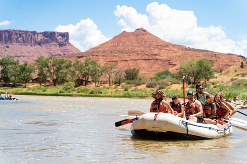 Guests in a raft on Castle Valley with beautiful red rock scenery surrounding