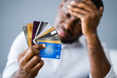 Man holding multiple credit cards considering debt consolidation options
