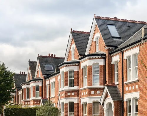 Knight Frank Wandsworth Estate Agents- row of Victorian terraced houses in Wandsworth, West London, characterized by red brick facades, white-framed bay windows, and slate roofs.