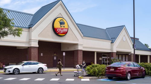 White car and Red car parked in front of Shop Rite