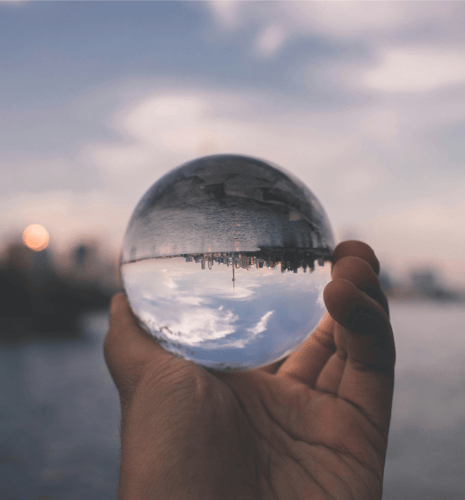 A person hold a glass ball, with a reflection of the Toronto skyline.
