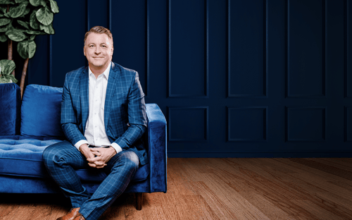 Jay Kilgannon sitting on a comfortable couch in a beautiful office setting.