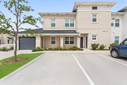 Front apartment home entry with parking in front at Camden Leander apartments in Leander, Tx