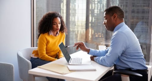 Woman meeting with her financial planner to review a year‑round tax strategy, discussing RRSP vs. TFSA contributions, asset location, and next steps to reduce tax drag.
