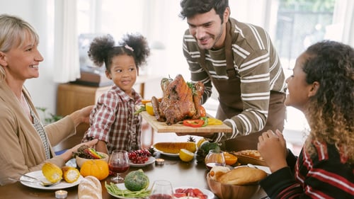 A happy family celebrating Thanksgiving dinner at home, embracing the tradition with joy and togetherness.
