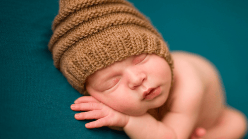 Baby wearing a brown beanie sleeping