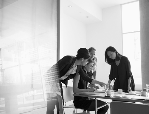 Four business women working at a table.