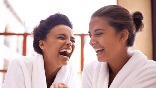 two women laughing in spa robes