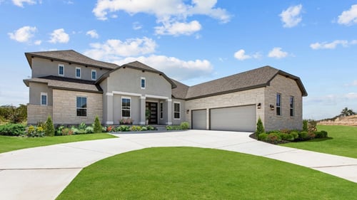 new home with stone exterior and large yard and driveway