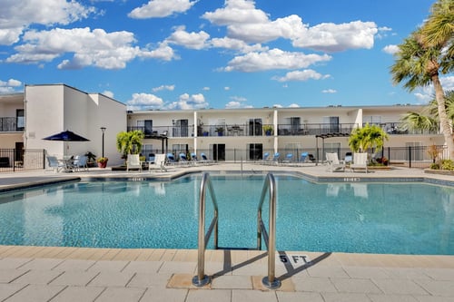 swimming pool in front of a building at Avia Apartments at Reedy Creek in Kissimmee, FL