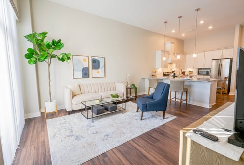 Spacious and open floor plan of a Brookwood Point apartment. The kitchen opens up to the living room, where natural light from the large windows fills the room.