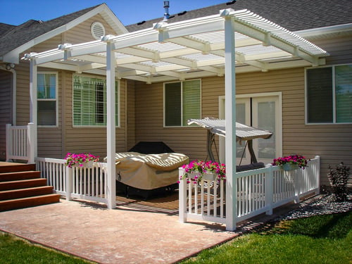 Custom white vinyl pergola and railing system installed over a concrete patio by DeckPro LLC in Rexburg, Idaho.