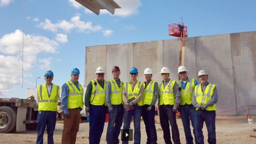 group of workers in a line wearing hardhats