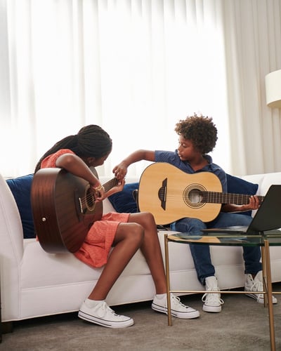 Mother and some guitar music lesson with laptop
