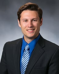 photo of Lucas Henningsen, MD smiling in front of a gray background.