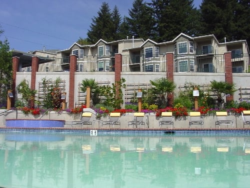 A pool in front of a building with a red brick column at Wilsonville Summit Apartments, Wilsonville , OR