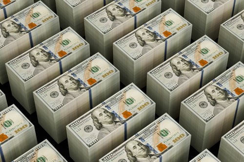 Rows of neatly stacked U.S. $100 bills arranged in a grid pattern against a dark background.