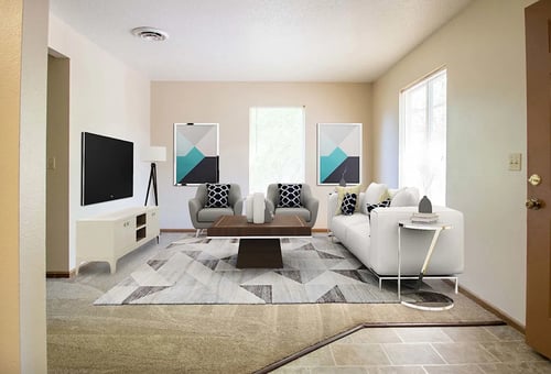 A living room with a white couch, a coffee table, and a television at Hunters Run Apartments, IA, 50208