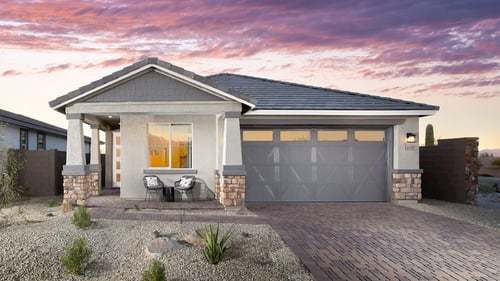 new single-story home with front patio chairs and stone driveway