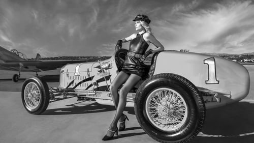 Woman posing next to a race car