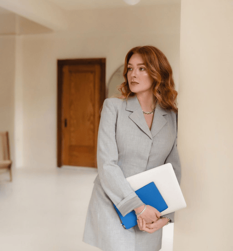 A portrait of Haley MacCosham holding a stack of notebooks.