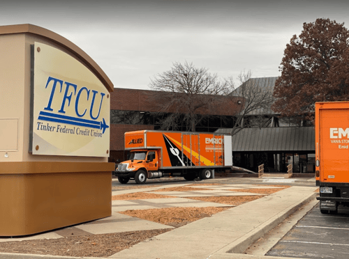 Orange moving trucks stationed in front of the Emrick's Van & Storage building