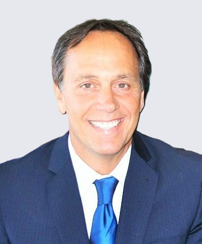 A man smiling in a suit.