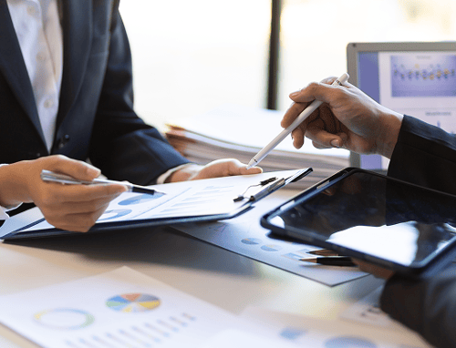 Close up of two people working on financial documents.