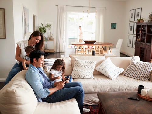 young-hispanic-family-sitting-on-sofa-reading-a-book