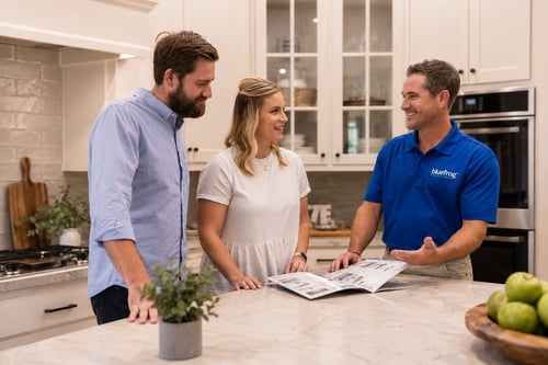 couple in kitchen talking to plumber