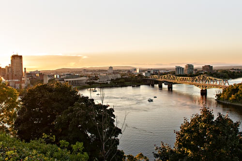 Aerial view of downtown Ottawa including the Alexandra Bridge over the Ottawa River at sunset.