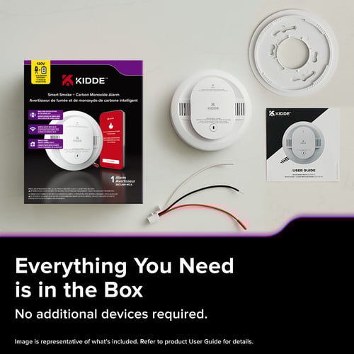 The box of the Kidde Smart Smoke and CO alarm is on a table with the contents inside laid out next to it. The text below reads " Everything you need is in the box, no additional devices required."