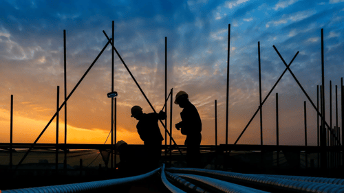 construction workers working on a project during the sunset