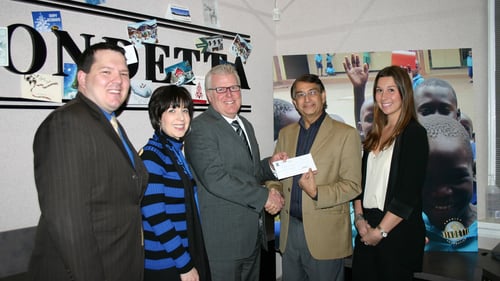 Greg presents a donation to Kish Modha of The Mondetta Clothing Company.