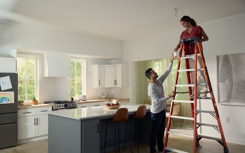 couple installing a carbon monoxide detector