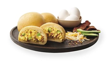 A kolache filled with scrambled eggs, fresh avocado, crispy bacon and cheddar cheese.