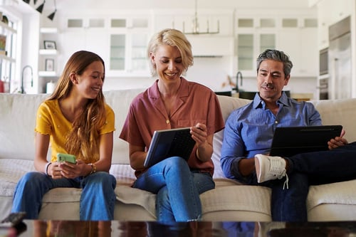 Family on couch using devices to connect to Wi-Fi
