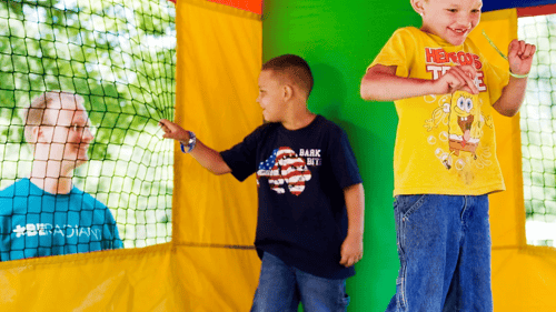 two kids jumping in a bounce house