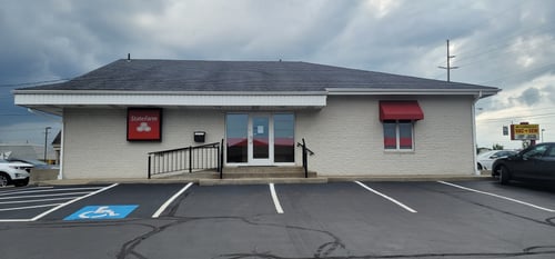 Brick building with red and white State Farm sign
