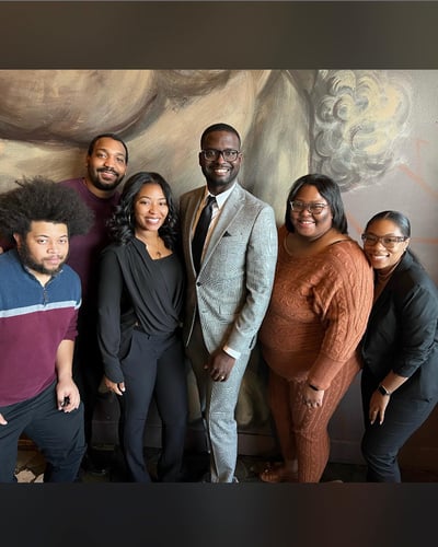 Agent Kandiss and five team members standing and smiling in office wearing professional attire