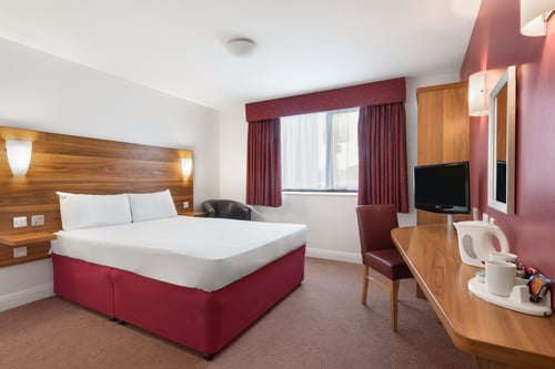 Bedroom with double bed, desk, TV and tea and coffee making facilities