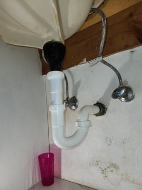 Inspecting shutoff valves under a lavatory sink.
