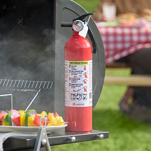 A fire extinguisher sits on a grill.