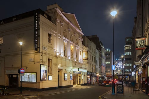 Side view of Harold Pinter Theatre at night
