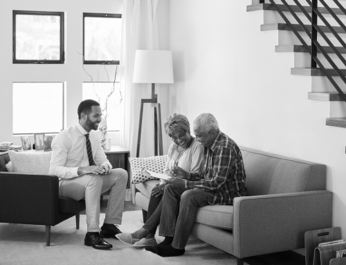 A senior couple meeting with an advisor in their living room.