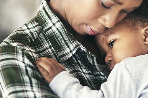 A compassionate embrace between a woman and child, representing the restoration of safety and comfort after a traumatic event.